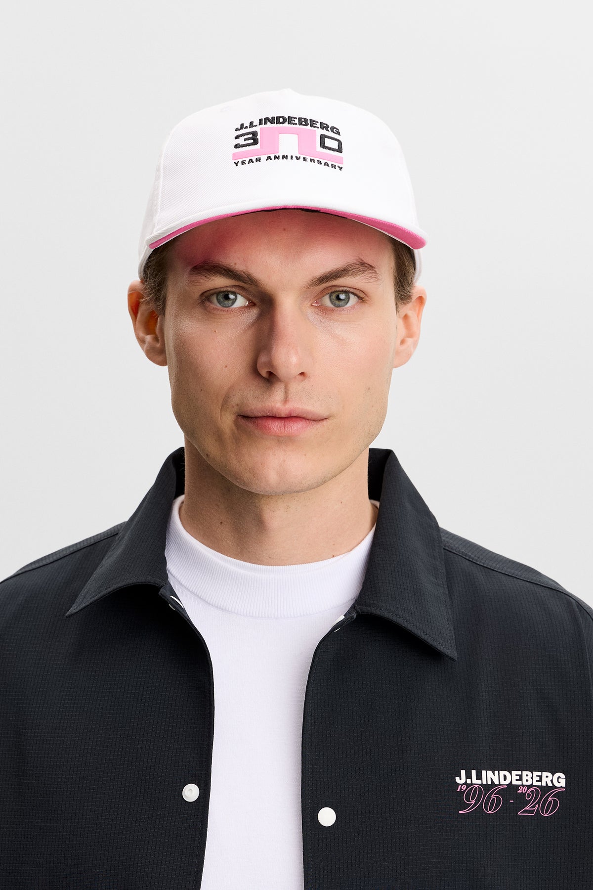 Šiltovka J.Lindeberg 30Y Anniversary Cap White – detail výročného brandingu na prednej a zadnej strane