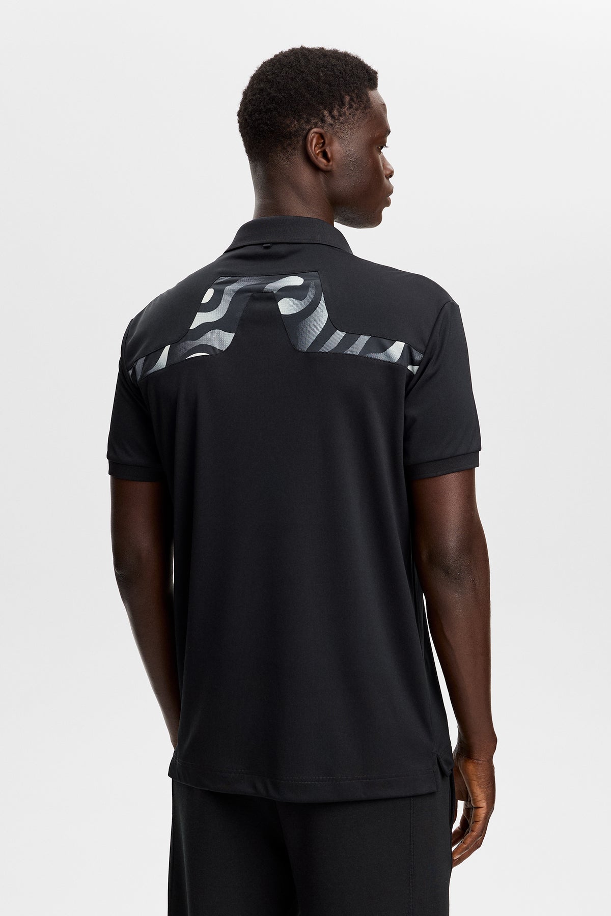 J.Lindeberg KV Print Polo Black – záber z ihriska demonštrujúci ochranu proti slnku UPF 40+